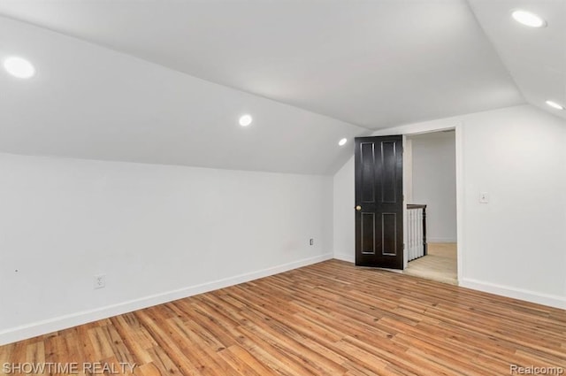 bonus room featuring lofted ceiling, light wood-style flooring, baseboards, and recessed lighting