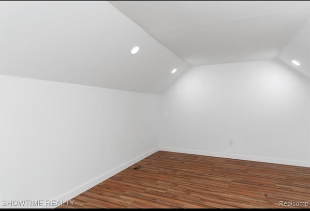 additional living space with vaulted ceiling, recessed lighting, wood finished floors, and baseboards