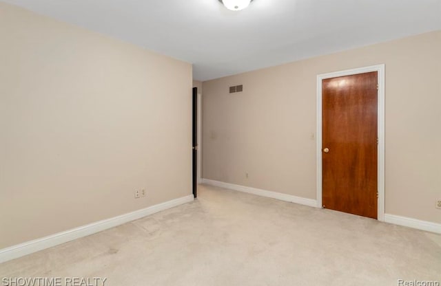 unfurnished bedroom with light carpet, visible vents, and baseboards