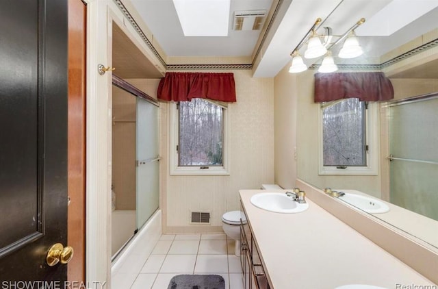 bathroom with a skylight, visible vents, toilet, tile patterned flooring, and vanity