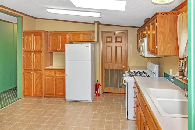 kitchen with lofted ceiling, a textured ceiling, white appliances, a sink, and light countertops