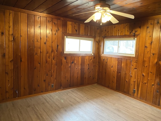 empty room with a ceiling fan, wooden ceiling, plenty of natural light, and wood finished floors