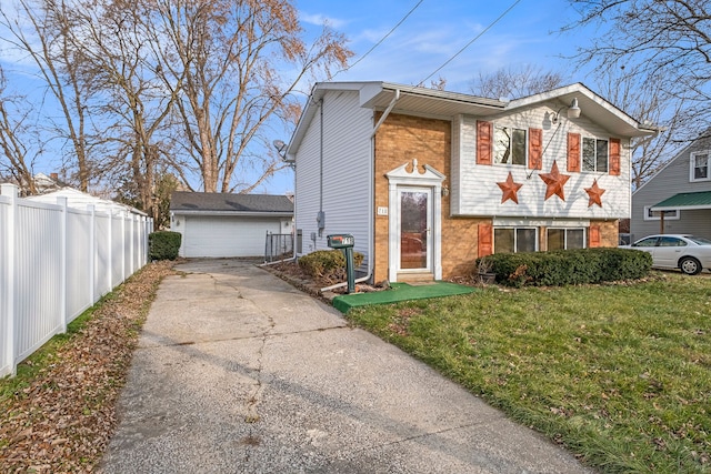 view of front of home with brick siding, fence, an outdoor structure, and a front yard