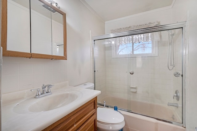 full bath with enclosed tub / shower combo, toilet, vanity, ornamental molding, and backsplash