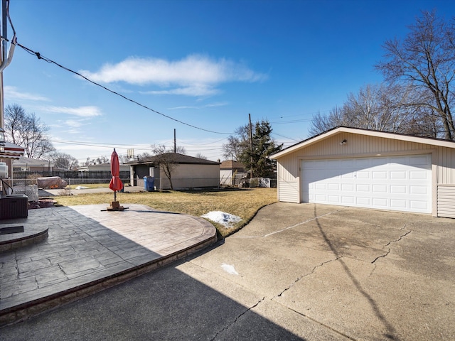 view of home's exterior featuring a garage, a lawn, an outdoor structure, and fence