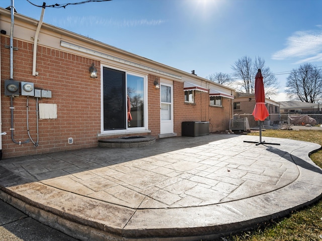 back of house featuring a patio, brick siding, and fence