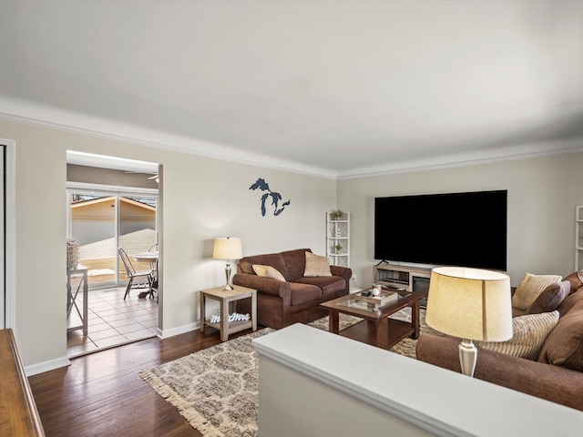 living area with ornamental molding, dark wood-type flooring, and baseboards