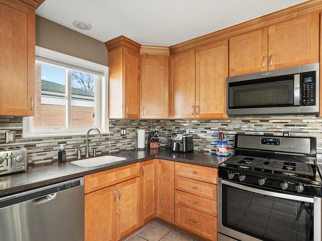 kitchen with appliances with stainless steel finishes, a sink, and tasteful backsplash