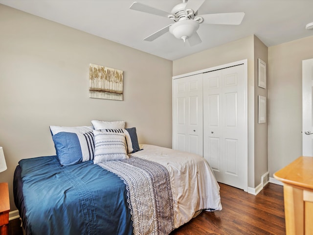 bedroom featuring ceiling fan, baseboards, dark wood finished floors, and a closet