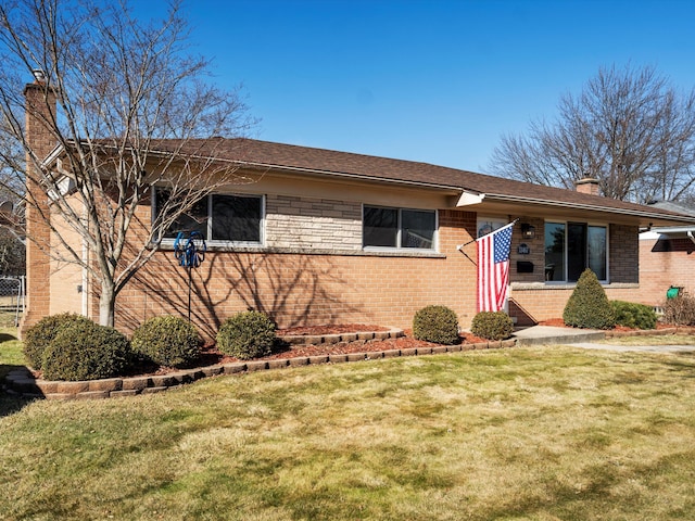 single story home with a front lawn, a chimney, and brick siding