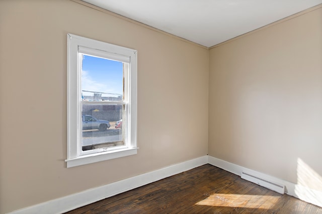 spare room featuring dark wood-style floors, a baseboard radiator, and baseboards