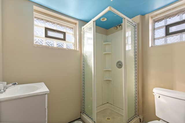 bathroom featuring a stall shower, vanity, and toilet