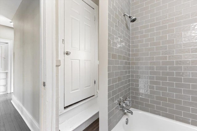 bathroom featuring shower / bath combination, baseboards, and wood finished floors