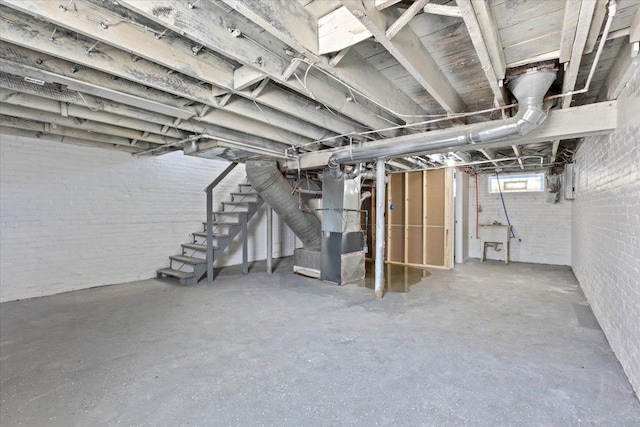 below grade area featuring heating unit, a sink, brick wall, and stairs