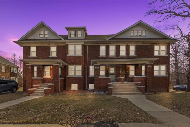 view of front facade with covered porch and brick siding