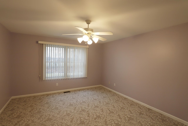 unfurnished room with a ceiling fan, carpet flooring, visible vents, and baseboards