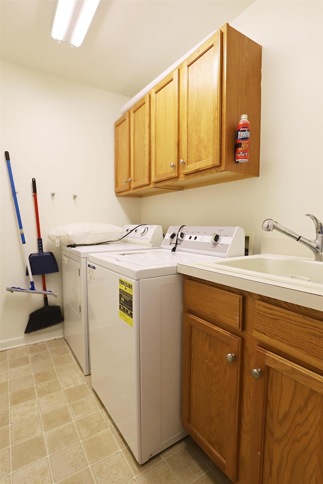 laundry area featuring a sink, cabinet space, light tile patterned floors, and washer and dryer