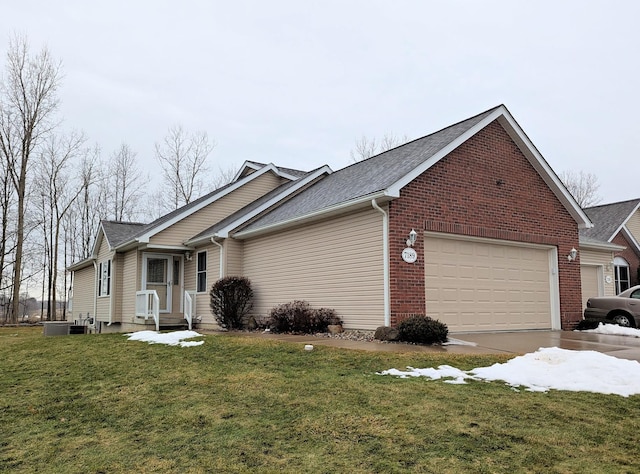 view of side of home with a garage, brick siding, and a yard