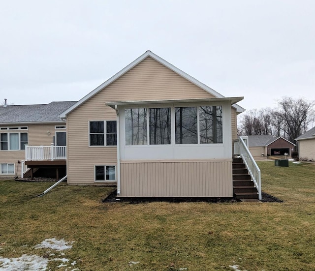 view of side of property with a sunroom, a lawn, and stairway