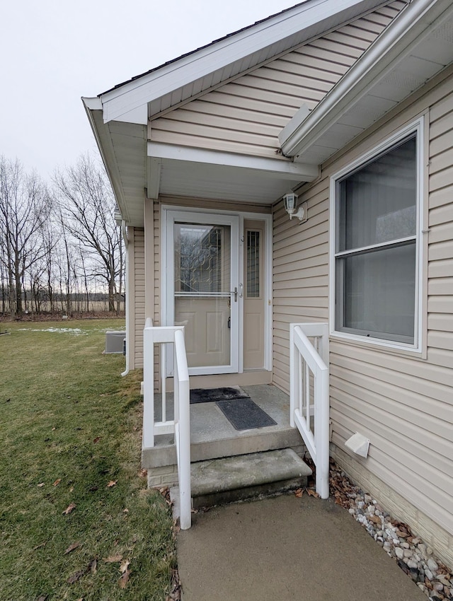 property entrance with a lawn