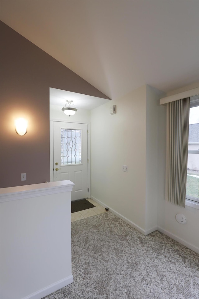 corridor with light carpet, lofted ceiling, and baseboards