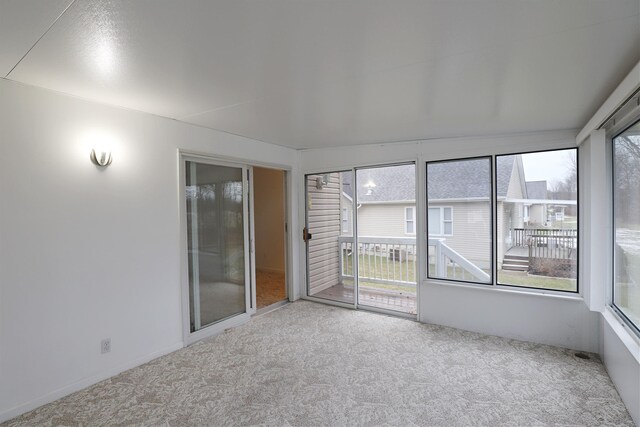 spare room with carpet flooring and a sunroom