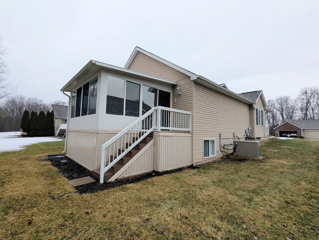 rear view of house featuring a sunroom, a lawn, and stairs