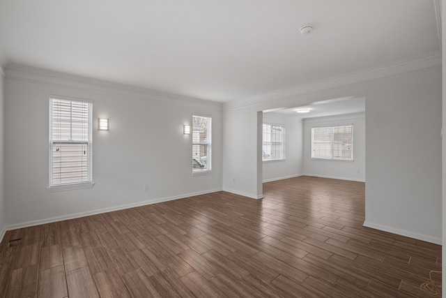 unfurnished room with dark wood-style flooring, a healthy amount of sunlight, and crown molding