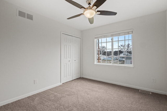 unfurnished bedroom featuring a closet, carpet, visible vents, and baseboards