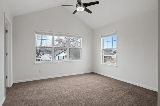 spare room featuring carpet floors, visible vents, a ceiling fan, vaulted ceiling, and baseboards