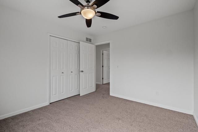 unfurnished bedroom with carpet floors, a closet, visible vents, and baseboards