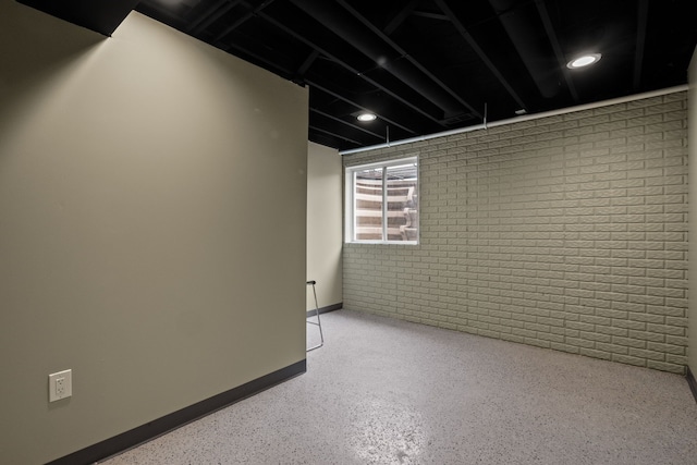 basement with brick wall and baseboards