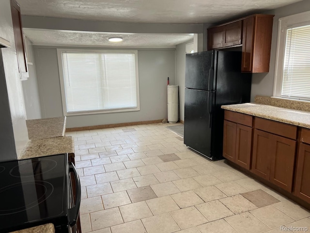 24067 Sargent Ave, Southfield, MI 48033 - kitchen featuring freestanding refrigerator, electric range, a textured ceiling, and baseboards