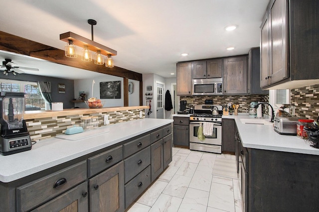 kitchen featuring marble finish floor, appliances with stainless steel finishes, a sink, and tasteful backsplash