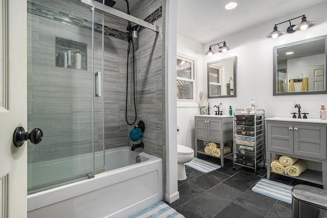 full bath with bath / shower combo with glass door, vanity, toilet, and baseboards