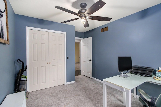 home office featuring a ceiling fan, light carpet, and baseboards