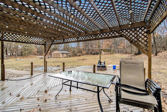 wooden deck featuring a pergola and an outbuilding