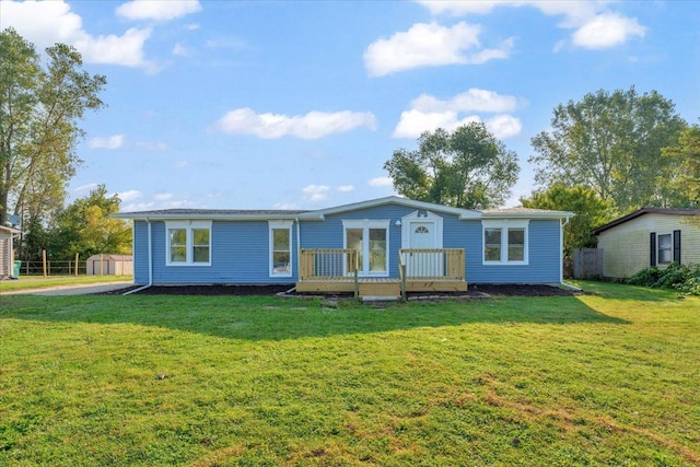 view of front of house featuring fence, a deck, and a front lawn