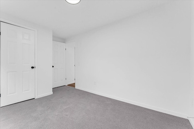 unfurnished bedroom featuring carpet floors and baseboards