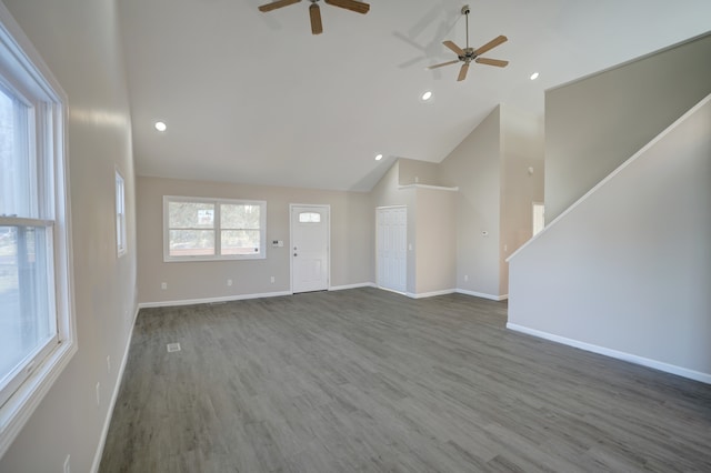 unfurnished living room featuring high vaulted ceiling, baseboards, and wood finished floors