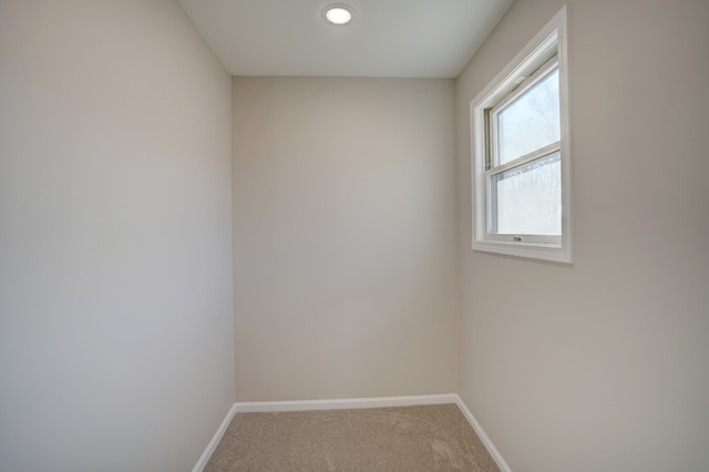 carpeted spare room featuring baseboards