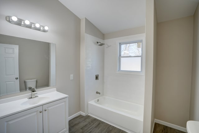 full bath featuring toilet, shower / tub combination, wood finished floors, baseboards, and vanity