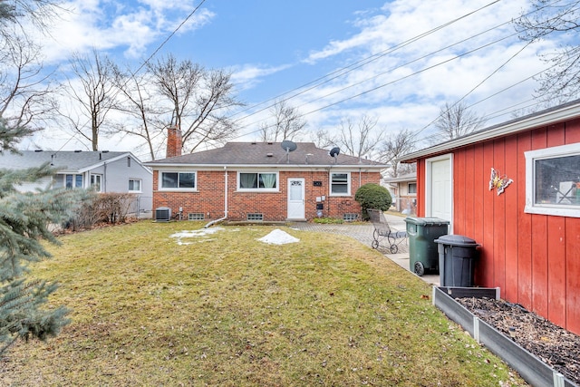 back of house with cooling unit, brick siding, a lawn, and a chimney