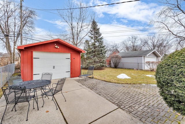 exterior space featuring an outbuilding, driveway, fence, and a garage