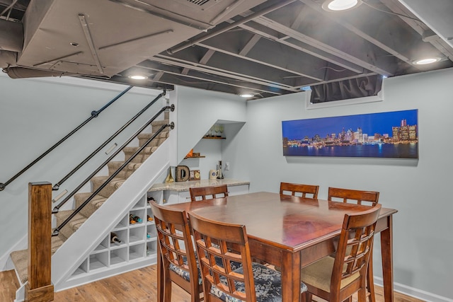 dining space featuring stairs, baseboards, and wood finished floors