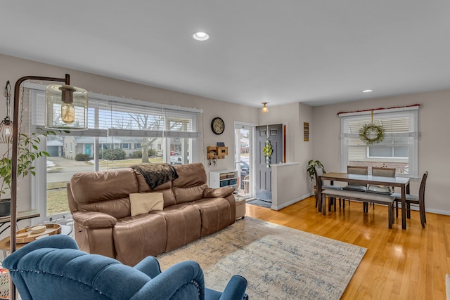 living room featuring baseboards, recessed lighting, and light wood-style floors