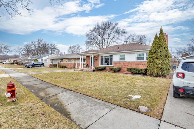 single story home with a front yard and brick siding