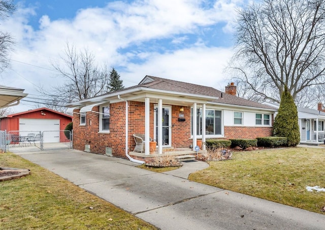 bungalow with an outbuilding, brick siding, a chimney, and a front yard