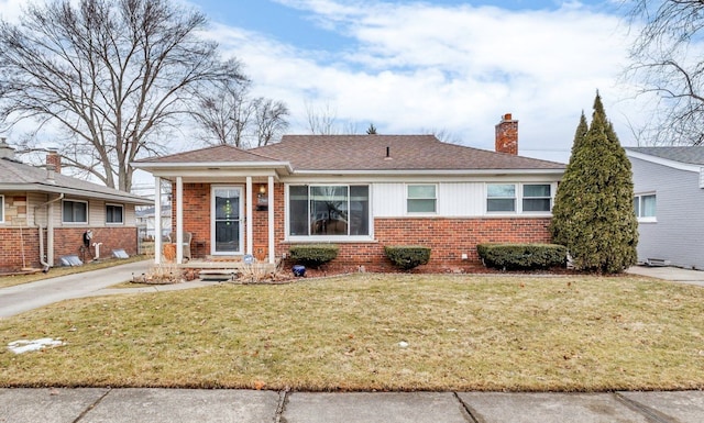 single story home featuring roof with shingles, a front yard, a chimney, and brick siding