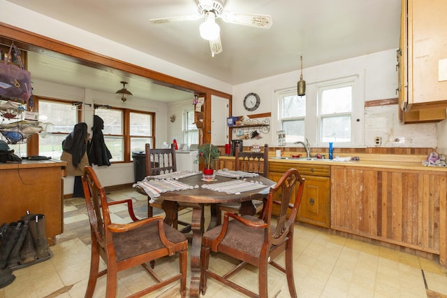 dining space with light floors, a wealth of natural light, and a ceiling fan